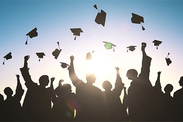 silhouettes of students throwing mortarboards