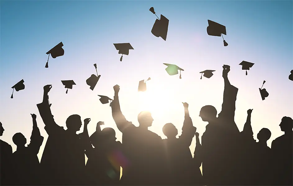 silhouettes of students throwing mortarboards.